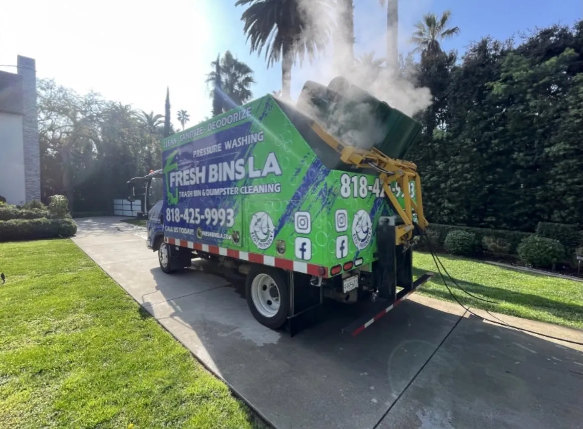 Fresh Bins LA truck at a residential curb with a hydraulic arm lifting a bin and steam rising