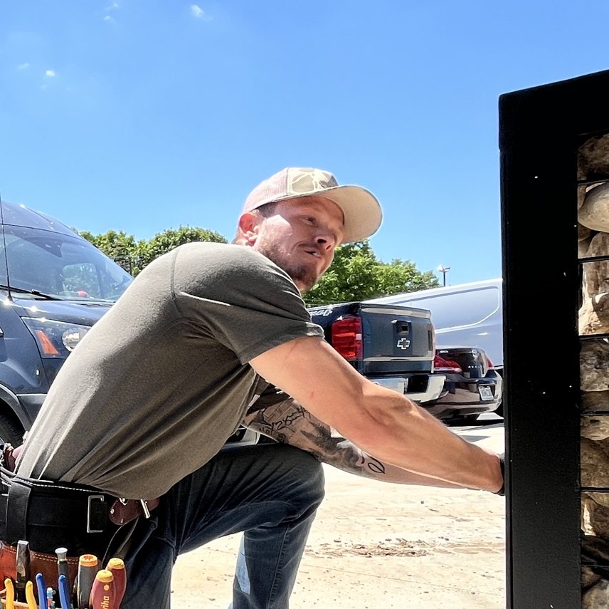 Tyler Gaumer, co-founder of Pipe Dream Electric, working beside the company van