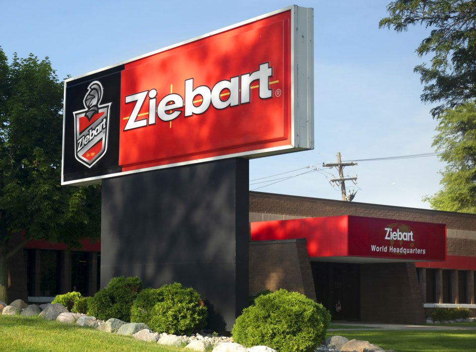 Red Ziebart sign with knight emblem in front of the brick Ziebart World Headquarters building